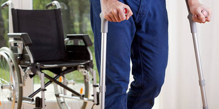 Horizontal view of a disabled man on crutches